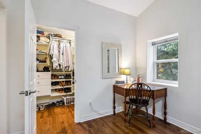 a view of a workspace with furniture and a window