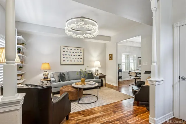a living room with furniture a chandelier and a window