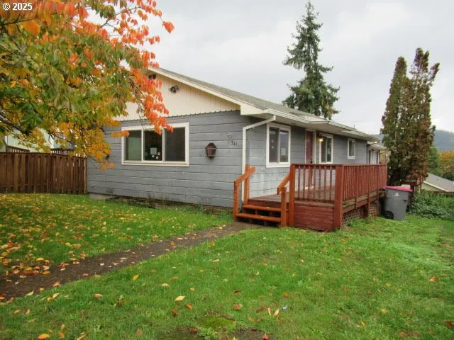 a view of a house with a yard and wooden fence