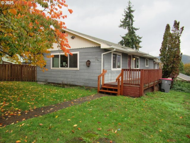 a view of a house with a yard and wooden fence