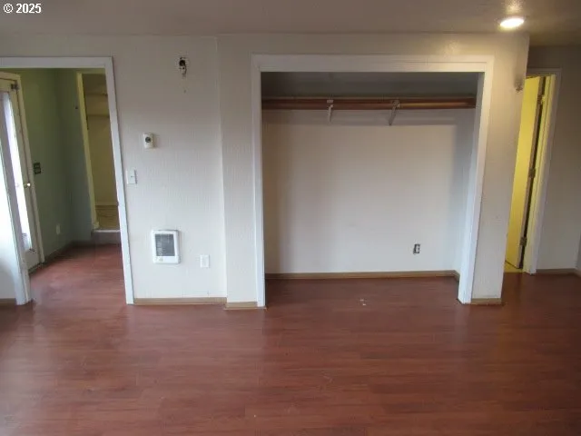 an empty room with wooden floor and closet
