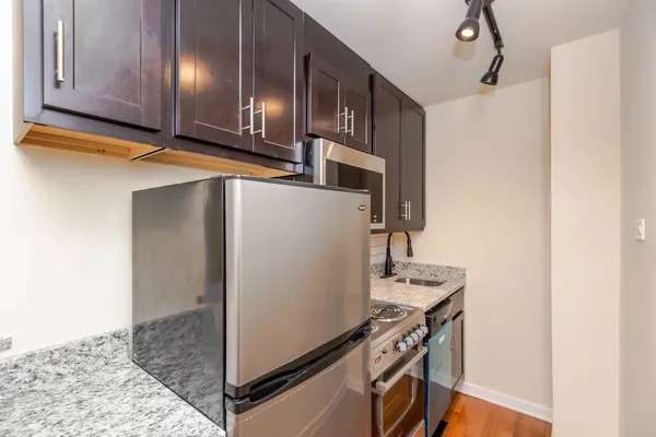 a kitchen with stainless steel appliances granite countertop a sink and a refrigerator