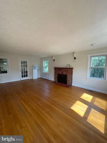 a view of empty room with wooden floor and fireplace