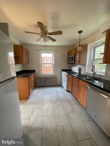 a large kitchen with stainless steel appliances granite countertop a sink and a stove