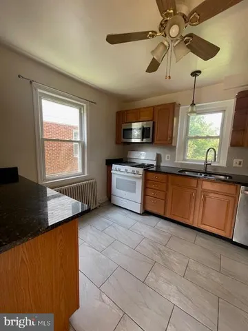 a kitchen with stainless steel appliances granite countertop a sink a stove top oven a counter space and cabinets