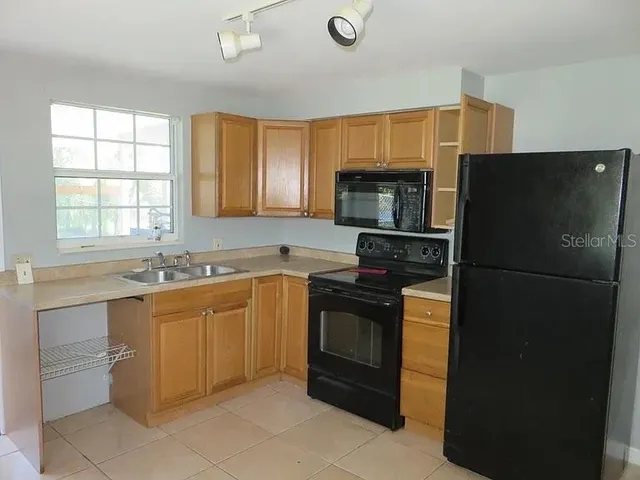 a kitchen with stainless steel appliances granite countertop a refrigerator and a sink