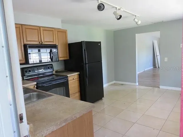 a kitchen with a refrigerator and a stove top oven