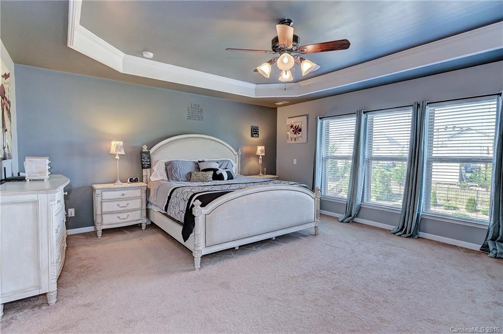 1428 Ridgehaven Road Waxhaw, NC 28173 - Photo 12 of 24 a spacious bedroom with a bed a chandelier and a large window