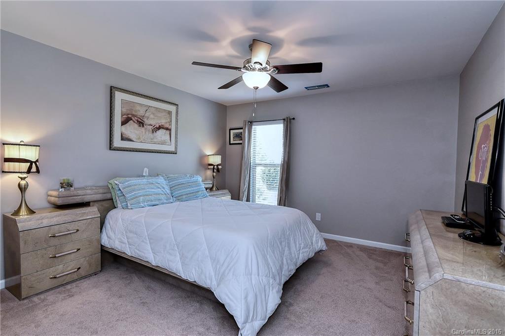 1428 Ridgehaven Road Waxhaw, NC 28173 - Photo 16 of 24 a bedroom with a large bed and a chandelier