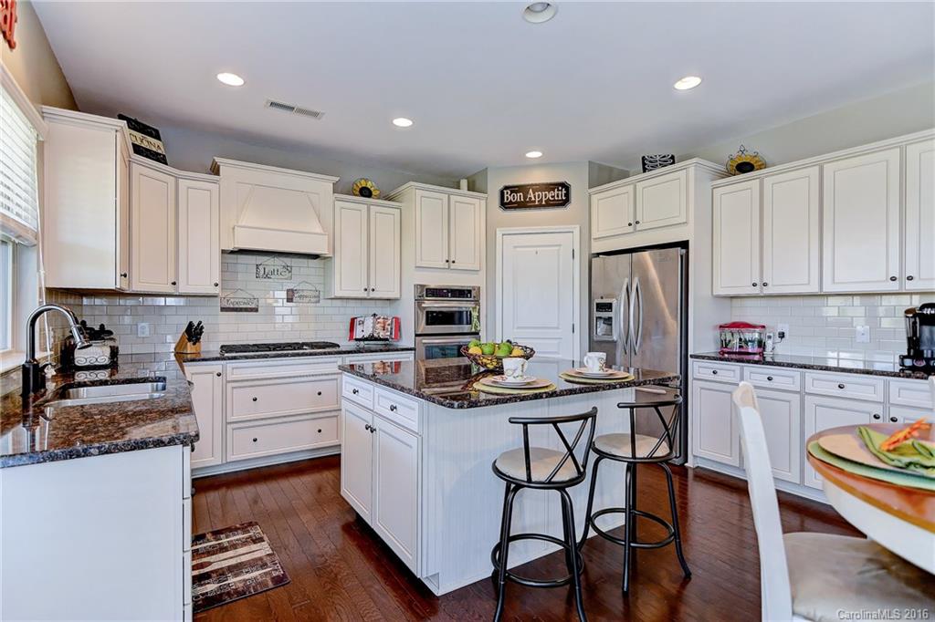 1428 Ridgehaven Road Waxhaw, NC 28173 - Photo 4 of 24 a kitchen with white cabinets and stainless steel appliances
