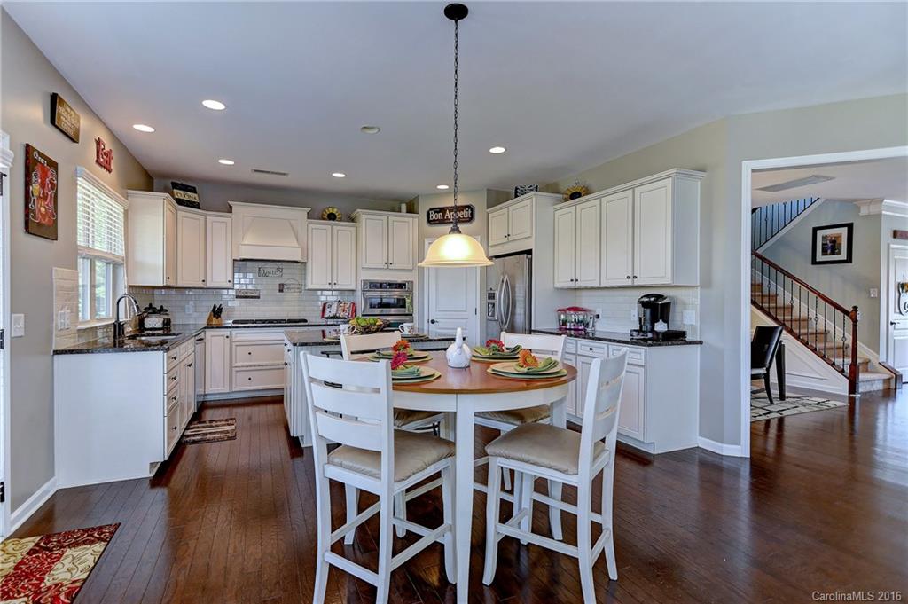 1428 Ridgehaven Road Waxhaw, NC 28173 - Photo 5 of 24 a kitchen with a dining table chairs refrigerator and cabinets