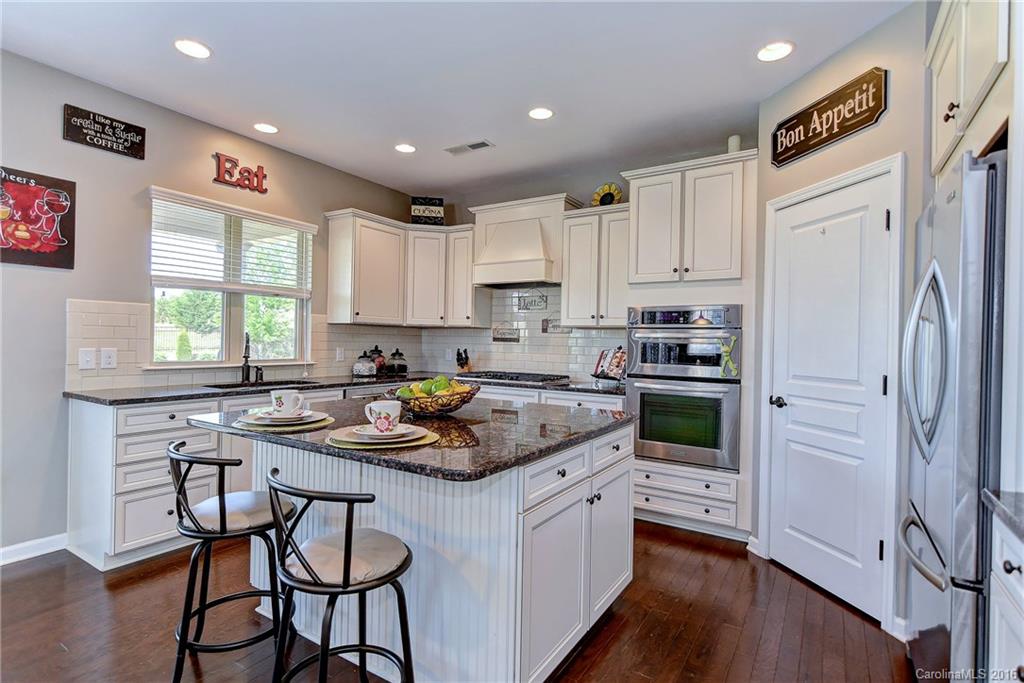 1428 Ridgehaven Road Waxhaw, NC 28173 - Photo 6 of 24 a kitchen with a refrigerator a stove a sink dishwasher and a refrigerator with wooden floor