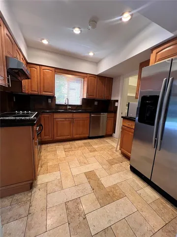 a kitchen with stainless steel appliances granite countertop a refrigerator and a stove