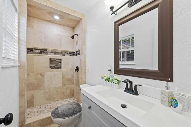 a bathroom with a sink a toilet and shower