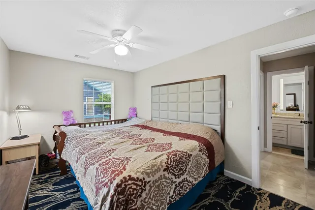 a bedroom with a large bed and a chandelier