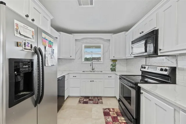 a kitchen with stainless steel appliances a stove a sink and a refrigerator