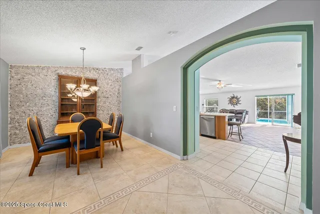 a view of a livingroom with furniture a fireplace and chandelier
