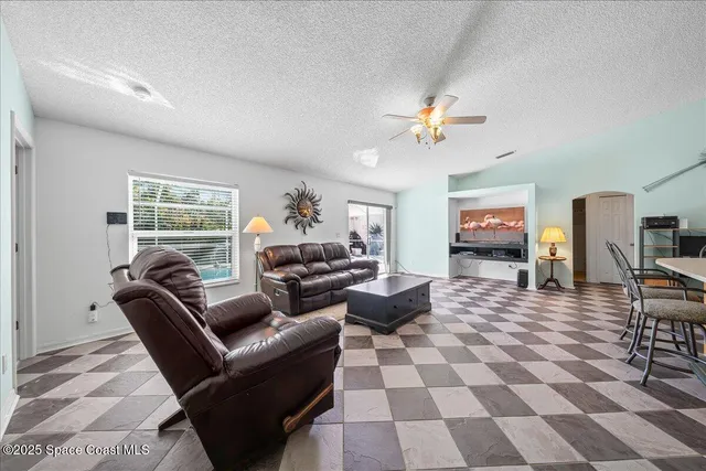 a living room with furniture a dining table and a piano with wooden floor