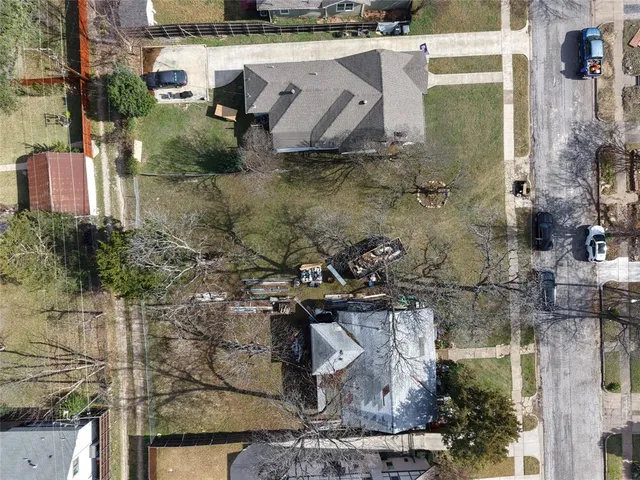 an aerial view of a house with a yard and large trees