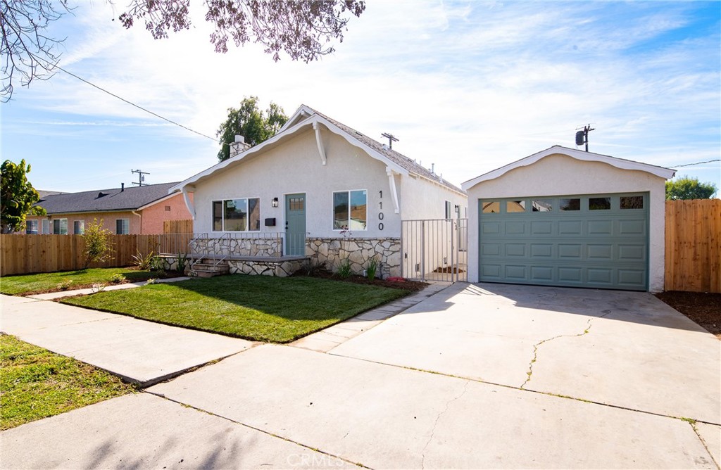 1100 East Tichenor Street Compton, CA 90221 - Photo 2 of 34 a front view of a house with a yard and garage