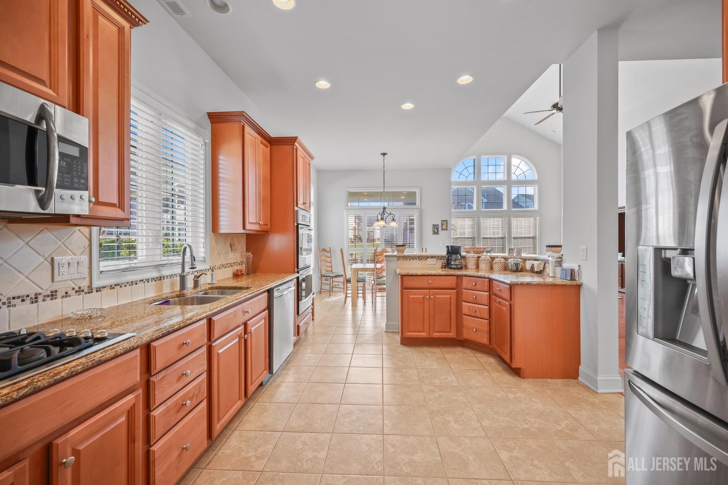 46 Mandrake Road Monroe Township, NJ 08831 - Photo 21 of 58 a large kitchen with stainless steel appliances granite countertop a refrigerator a sink dishwasher a oven with the countertops and cabinets next to a window