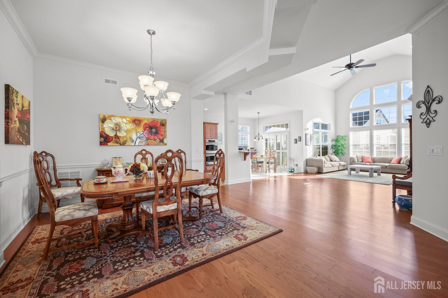 46 Mandrake Road Monroe Township, NJ 08831 - Photo 10 of 58 a dining room with wooden floor a chandelier a wooden table and chairs