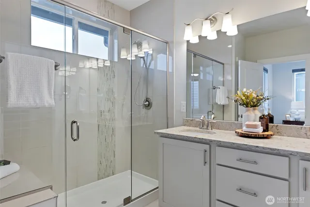 a bathroom with a sink a large mirror and shower