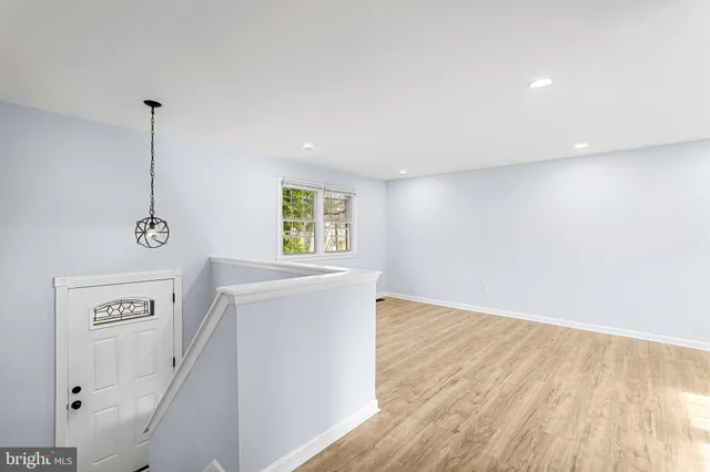 a view of empty room with window and wooden floor