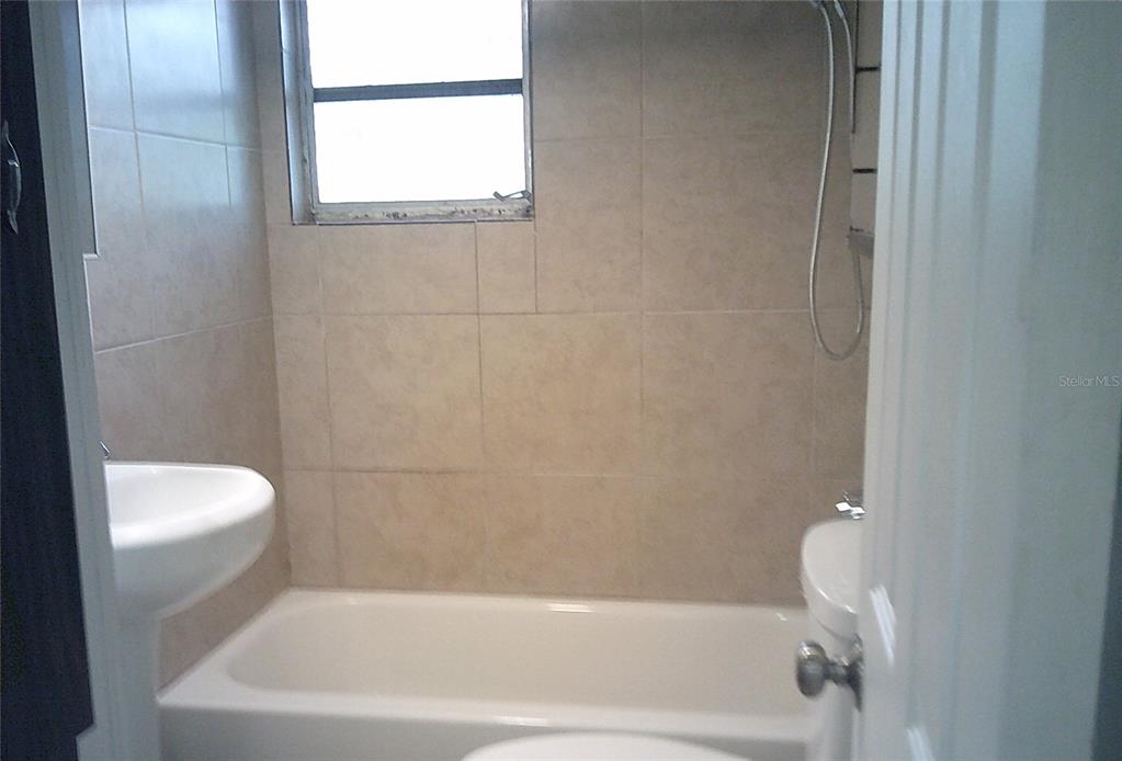 1060 65th Street South St. Petersburg, FL 33707 - Photo 16 of 20 a bath tub sitting next to a white toilet