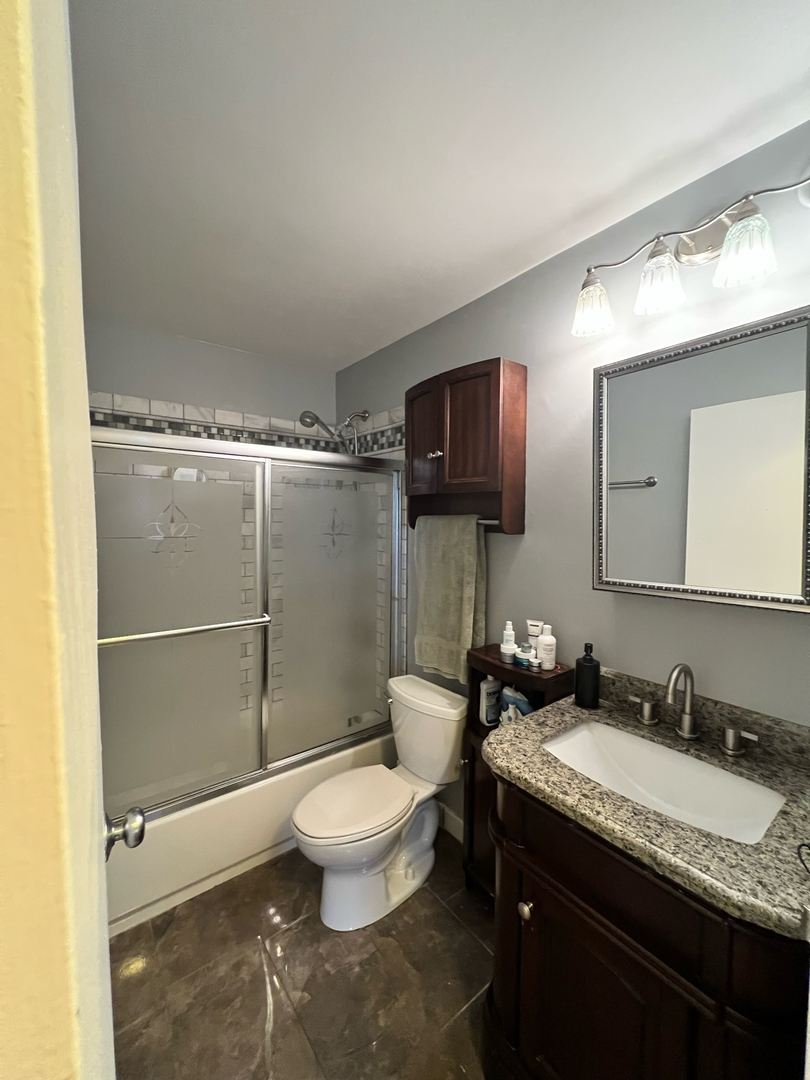 5320 North Sheridan Road, Unit 401 Chicago, IL 60640 - Photo 11 of 17 a bathroom with a granite countertop sink toilet and shower