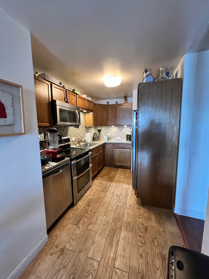5320 North Sheridan Road, Unit 401 Chicago, IL 60640 - Photo 9 of 17 a kitchen with stainless steel appliances granite countertop a refrigerator and a sink