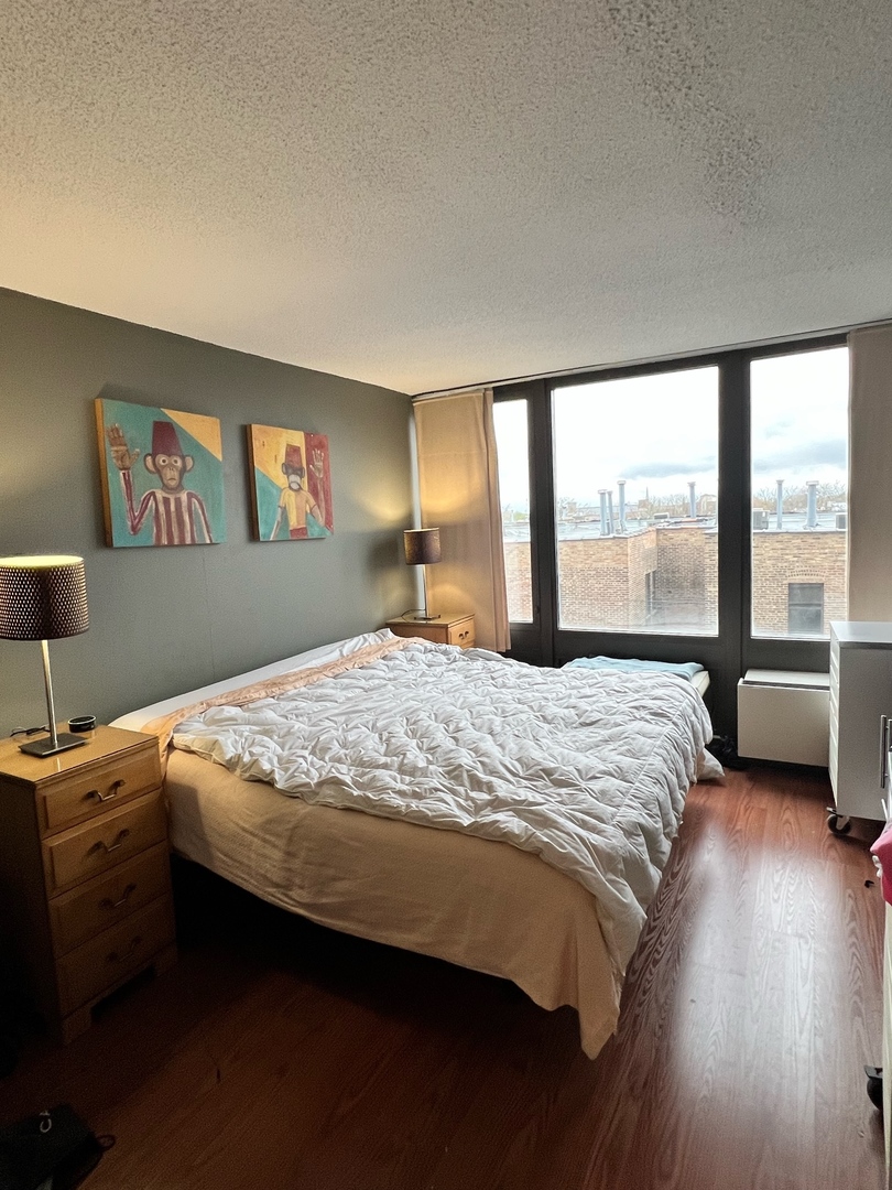 5320 North Sheridan Road, Unit 401 Chicago, IL 60640 - Photo 10 of 17 a bedroom with a large bed and a large window