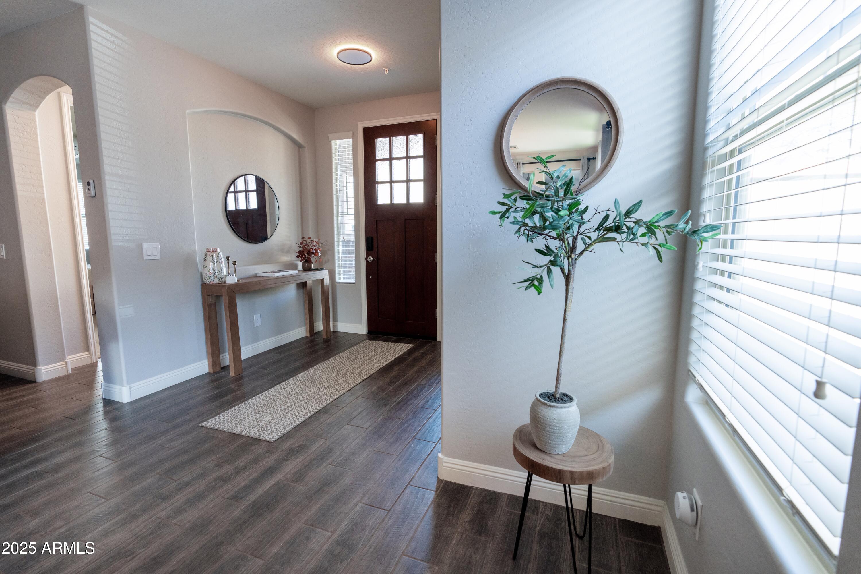 20753 West Legend Trail Buckeye, AZ 85396 - Photo 2 of 21 a view of a livingroom with furniture a chandelier and wooden floor