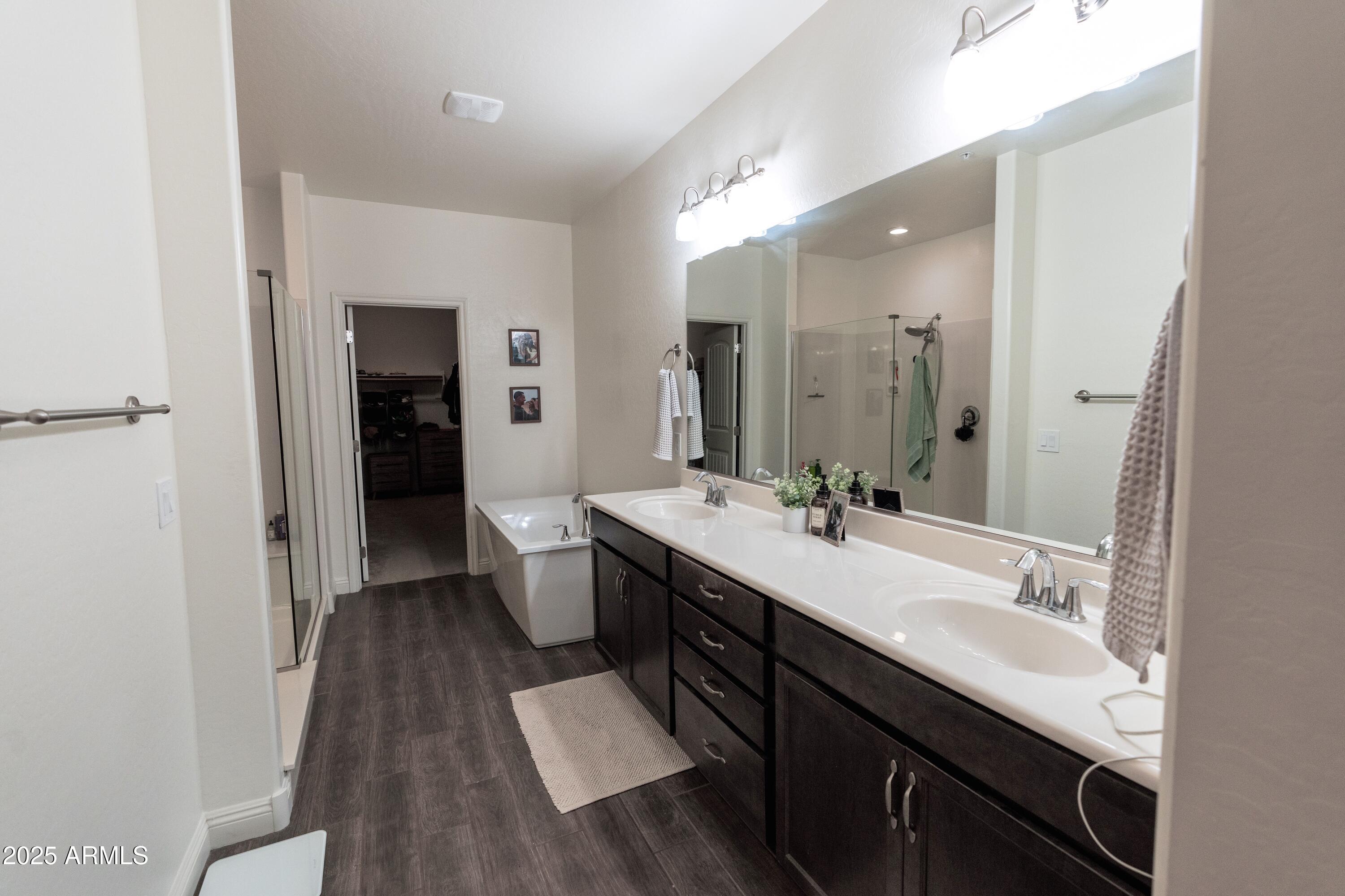 20753 West Legend Trail Buckeye, AZ 85396 - Photo 9 of 21 a spacious bathroom with a double vanity sink and a mirror