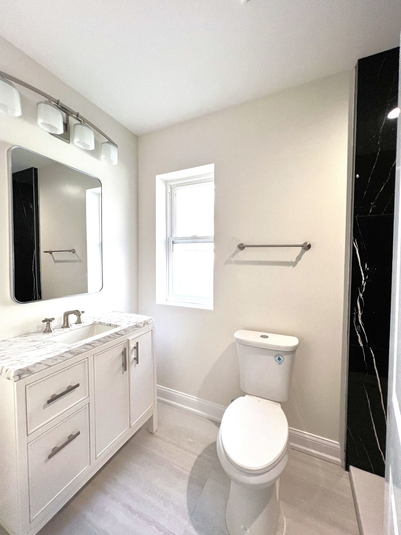 5320 West Ohio Street Chicago, IL 60644 - Photo 19 of 27 a bathroom with a toilet sink and mirror