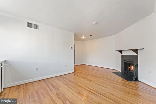 a view of empty room with wooden floor and fireplace