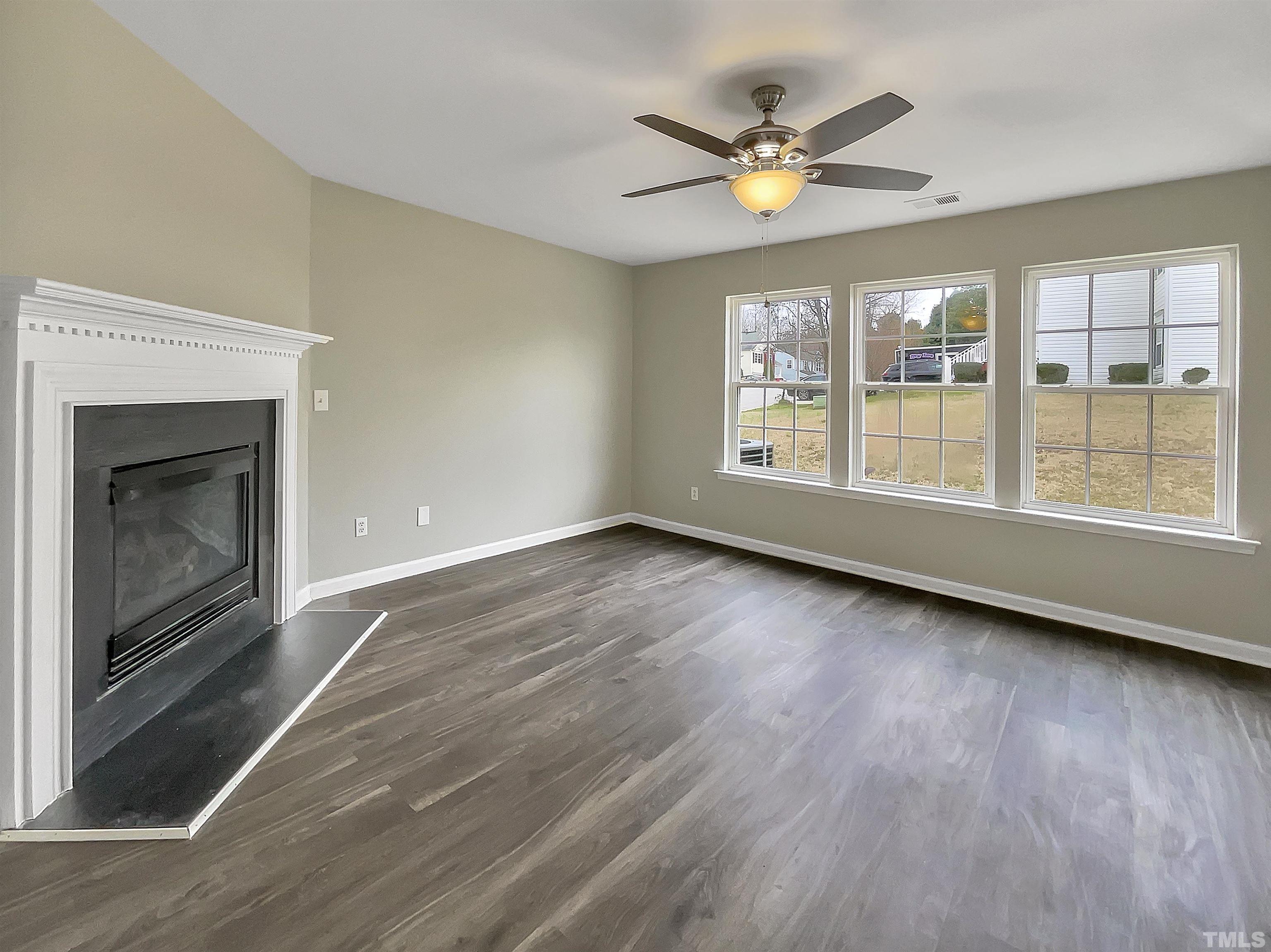 3360 Marshlane Way Raleigh, NC 27610 - Photo 3 of 17 an empty room with wooden floor fan and windows