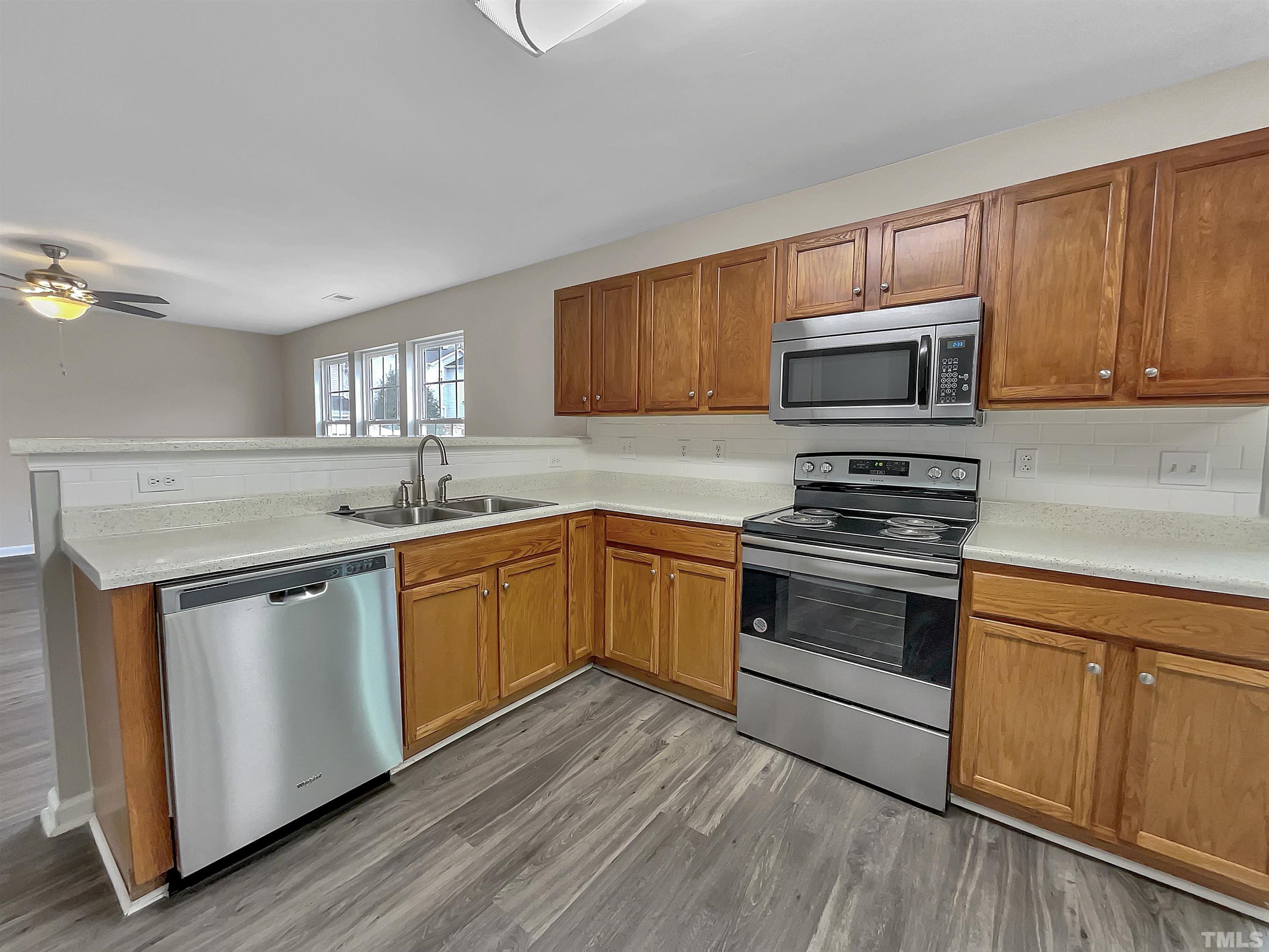 3360 Marshlane Way Raleigh, NC 27610 - Photo 10 of 17 a kitchen with sink a microwave and cabinets