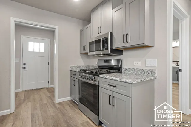 a kitchen with stainless steel appliances granite countertop a stove and a microwave