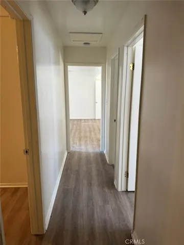a view of a hallway with wooden floor