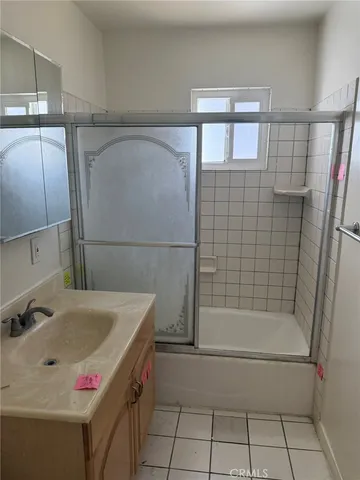 a bathroom with a tub sink vanity and mirror