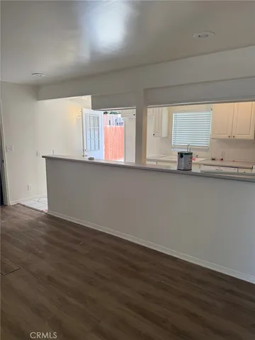 an empty room with wooden floor and window