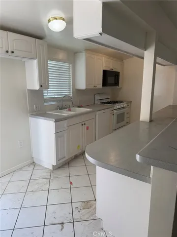 a kitchen with a sink a stove top oven and cabinets