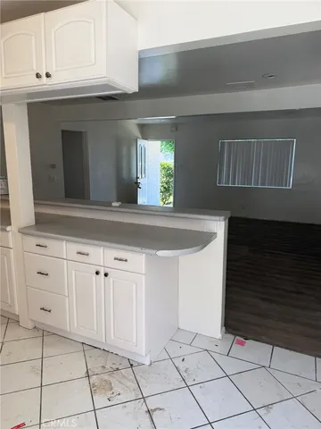 a kitchen with granite countertop white cabinets and white appliances