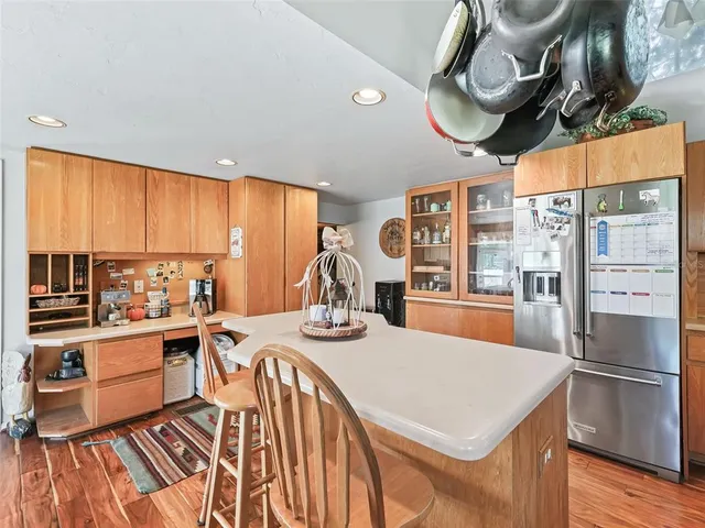 a kitchen with stainless steel appliances granite countertop a stove a sink dishwasher and a dining table with wooden cabinet
