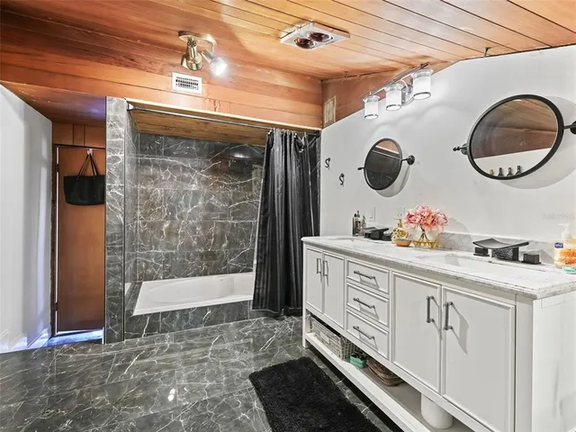 a bathroom with a double vanity sink mirror and shower