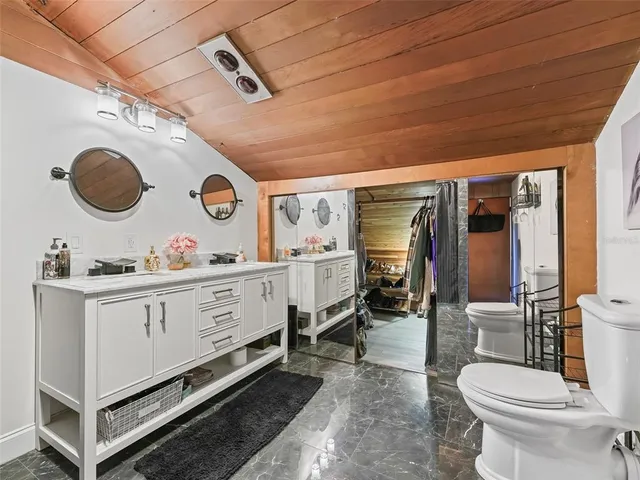 a spacious bathroom with a toilet a sink and mirror