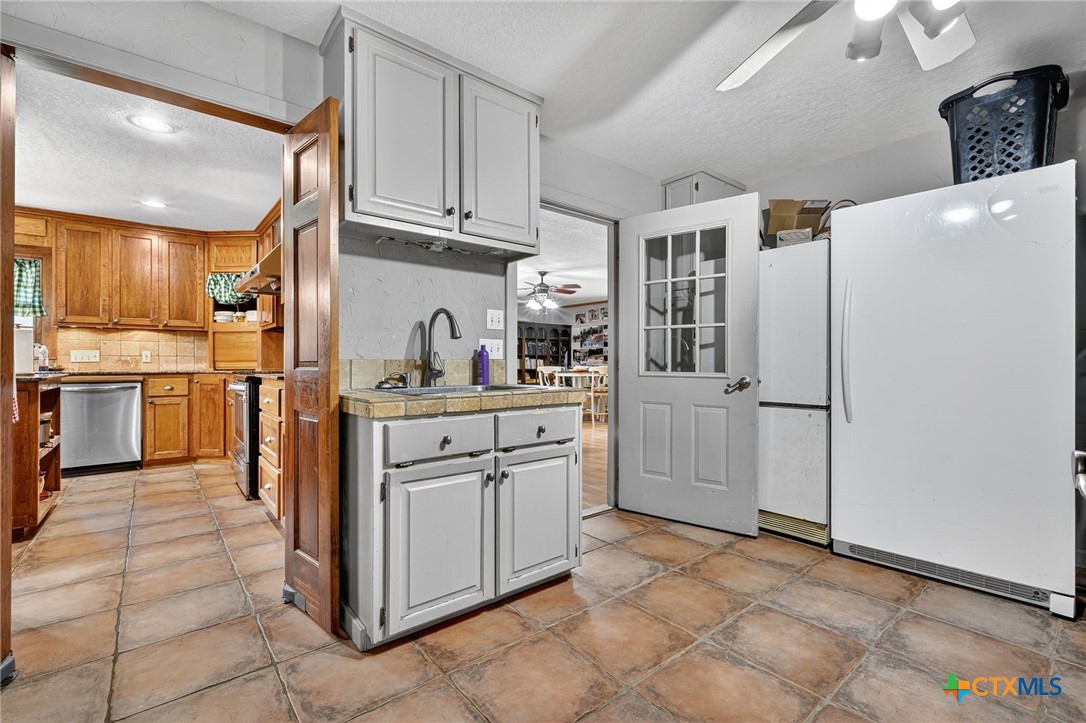 725 County Road 300 Hamilton, TX 76531 - Photo 14 of 41 a kitchen with cabinets and a refrigerator