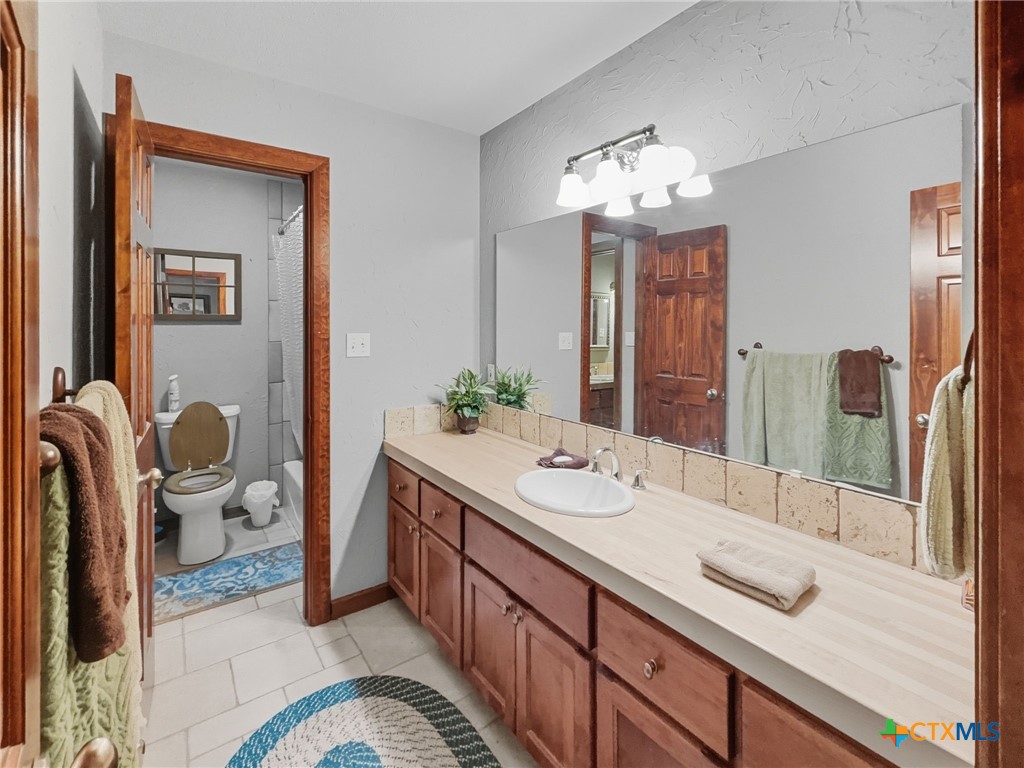 725 County Road 300 Hamilton, TX 76531 - Photo 17 of 41 a spacious bathroom with a double vanity sink and a mirror