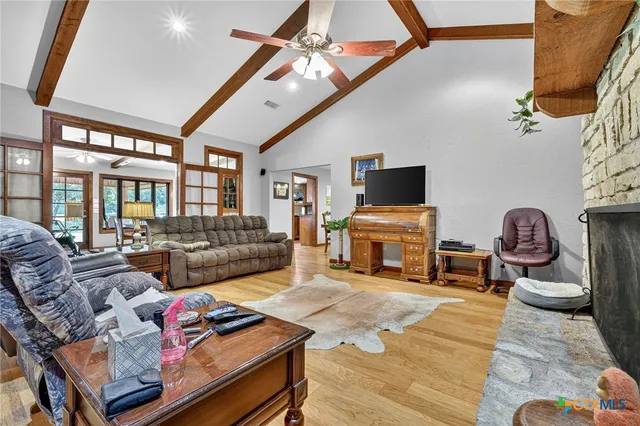 a living room with furniture a flat screen tv and a floor to ceiling window
